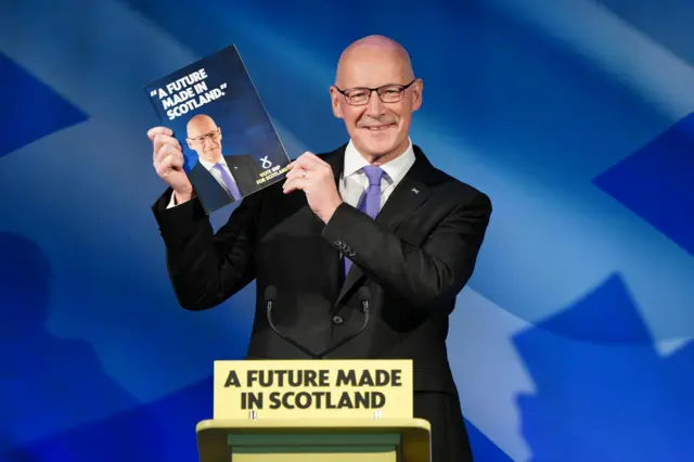 SNP first minister John Swinney with their manifesto