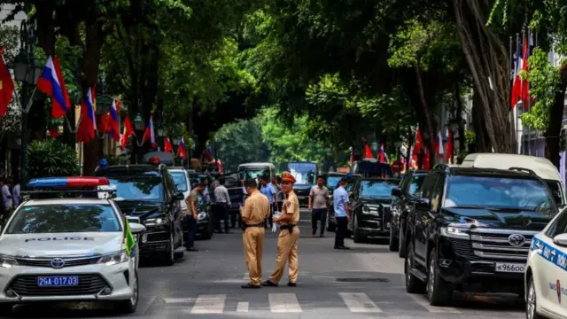 Police officers stand guard outside Hotel Metropole Hanoi