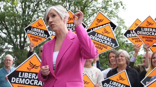 Lib Dem deputy leader Daisy Cooper with campaigners holding party signs