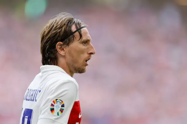 Modric looks on at the play