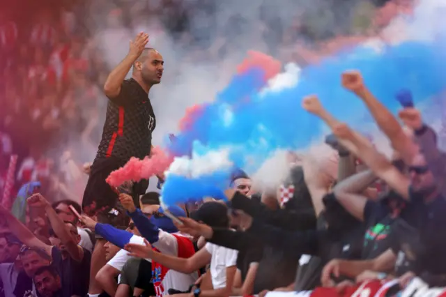 Croatian fans shout and light flares in celebration