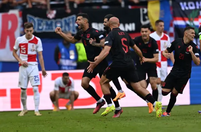 Gjasula is mobbed by teammates after scoring the equaliser