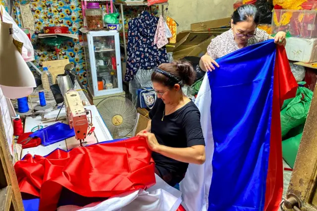 Workers in Hanoi prepare Russian national flags ahead of Putin's visit