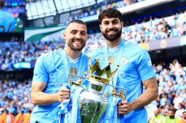 Mateo Kovacic and Josko Gvardiol holding the Premier League trophy