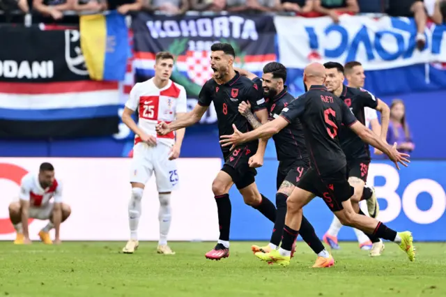 Gjasula celebrates his stoppage time equaliser with team mates