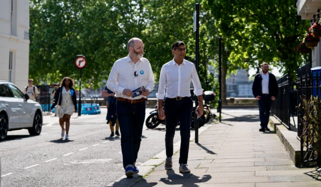 Rishi Sunak walking down a London street