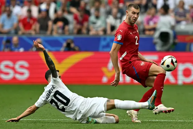 Strahinja Pavlovic (R) fights for the ball with Slovenia's defender #20 Petar Stojanovic