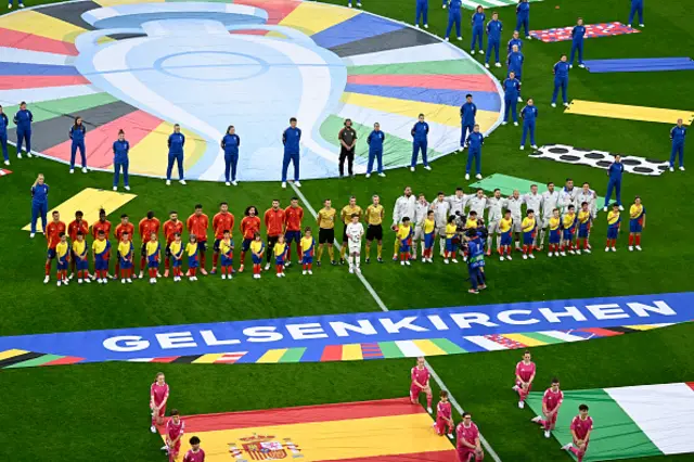 Spain's players (L) and Italy's players attend their national anthems