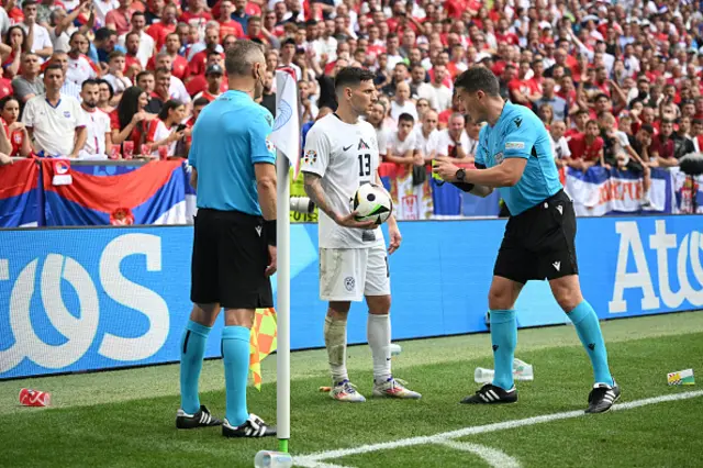 Erik Janza of Slovenia speaks with Referee Istvan Kovacs after clearing plastic cups