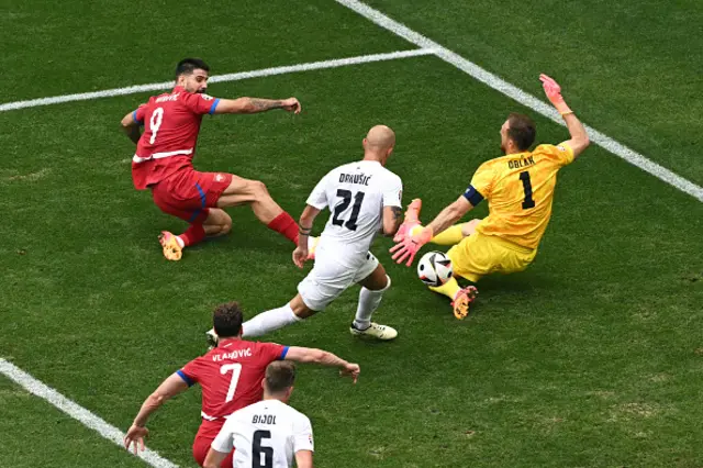 Slovenia's goalkeeper Jan Oblak (R) deflects a shot by Serbia's forward Aleksandar Mitrovic