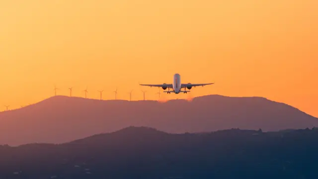 Plane flying to windfarm