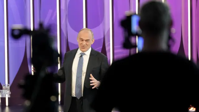 Ed Davey on the Question Time stage in front of a camera and cameraman