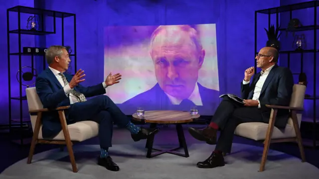 Nigel Farage speaks to Nick Robinson in the studio in front of a photograph of Vladimir Putin