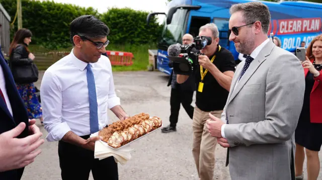 Rishi Sunak hands out buttered slices of Welsh fruit cake