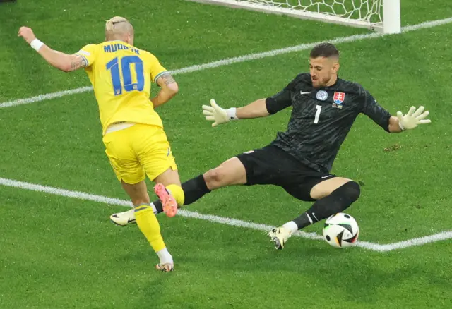 Mykhailo Mudryk of Ukraine (L) and Slovakia goalkeeper Martin Dubravka in action