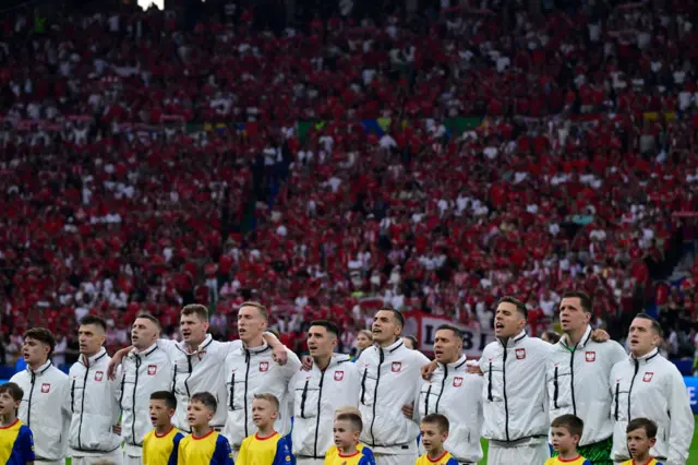 Poland players sing the national anthem