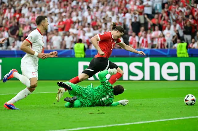 Marcel Sabitzer tries to dribble past Poland's goalkeeper Wojciech Szczesny and gets fouled