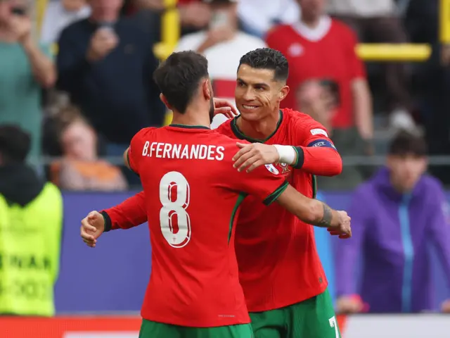 Fernandes and Ronaldo embrace after they combine for the third goal