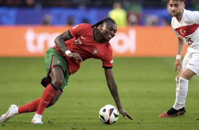 Portugal's Rafael Leao (left) and Turkey's Yunus Akgun battle for the ball