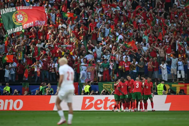 Portugal players celebrate as a Turkey players stands desconsolate