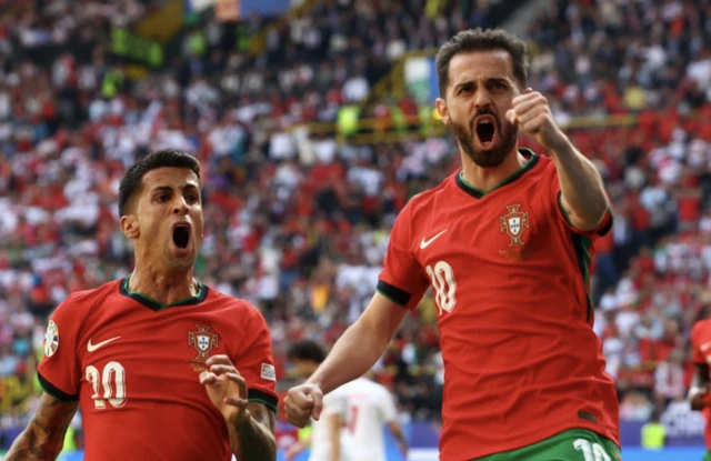 Portugal's Bernardo Silva celebrates scoring their first goal with Joao Cancelo