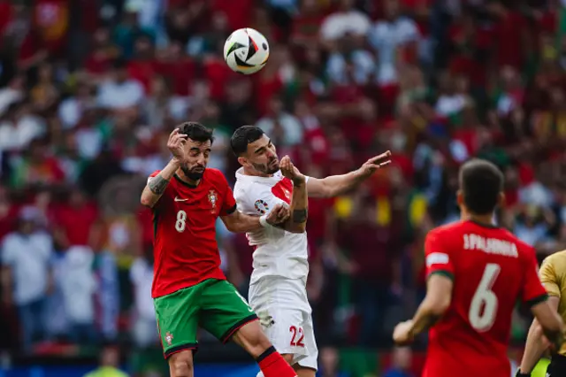 Bruno Fernandes of Portugal (L) jumps for a header with Kaan Ayhan