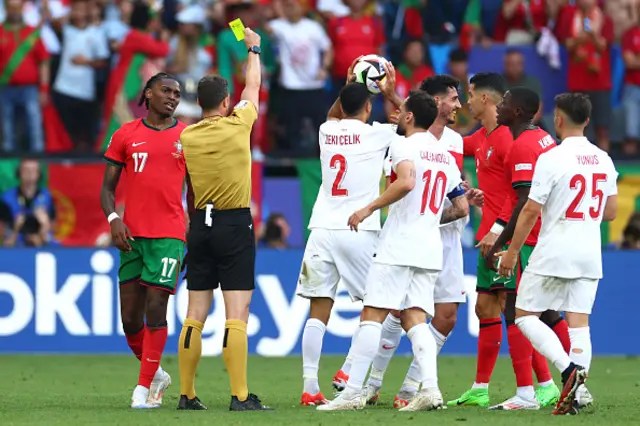 Referee Felix Zwayer shows a yellow card to Zeki Celik