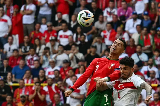 Cristiano Ronaldo (L) fights for the ball with Turkey's defender #04 Samet Akaydin