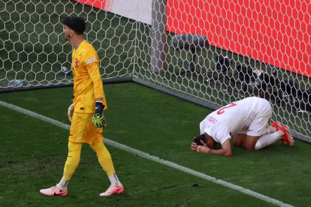 Turkey defender falls to the floor after the own goal