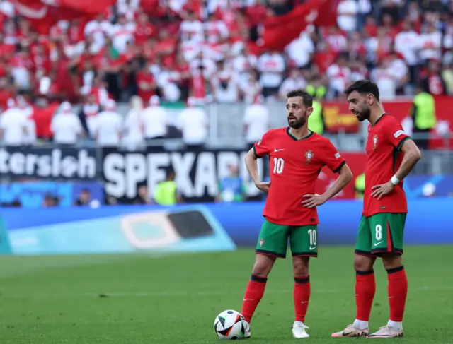 Silva and Fernandes stand over a free kick