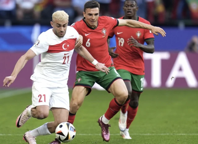 Turkey's Baris Alper Yilmaz (left) and Portugal's Joao Palhinha battle for the ball