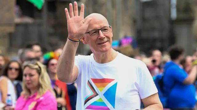 Leader of the SNP John Swinney in Edinburgh at the city's Pride March, where he's pictured waving.