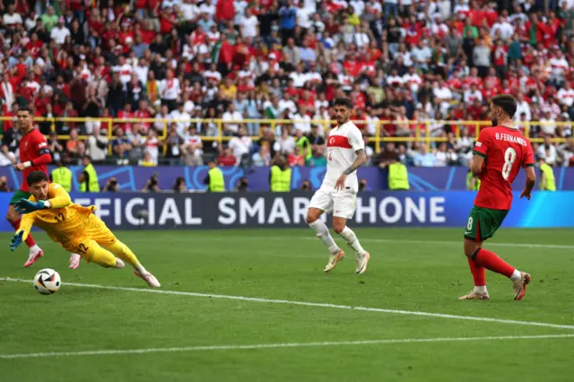 Fernandes sweeps the ball home past Bayindir for Portugal's third goal