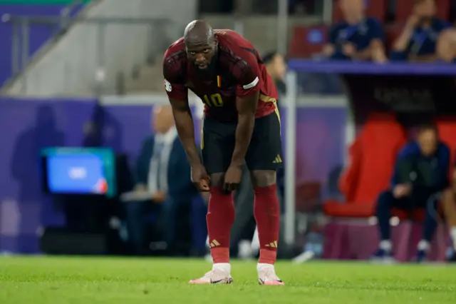 Lukaku stands frustrated and pulls his socks up