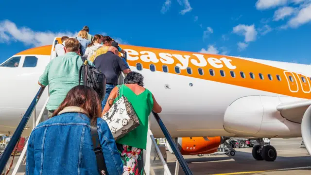 A view of people climbing the stairs to board an Easyjet flight.