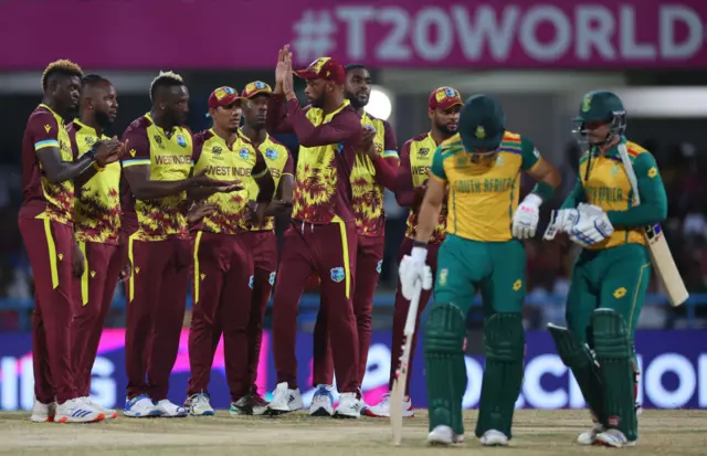 West Indies players wait for the outcome of a review