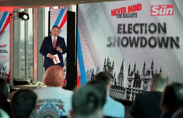 The Sun's Political Editor Harry Cole in front of a 'Never Mind the Ballots' election special sign