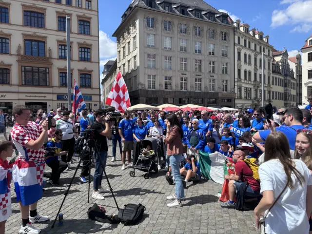 Italy and Croatia fans pose for a live tv interview