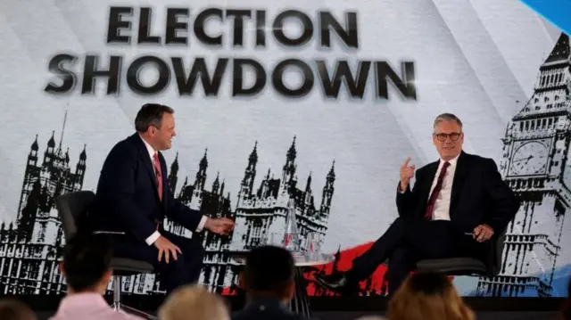 Harry Cole sits next to Keir Starmer on stage during The Sun's election Q&A