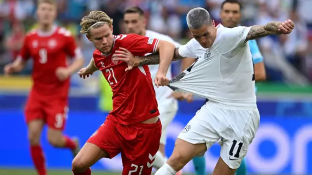 Morten Hjulmand of Denmark pulls the shirt of Benjamin Sesko