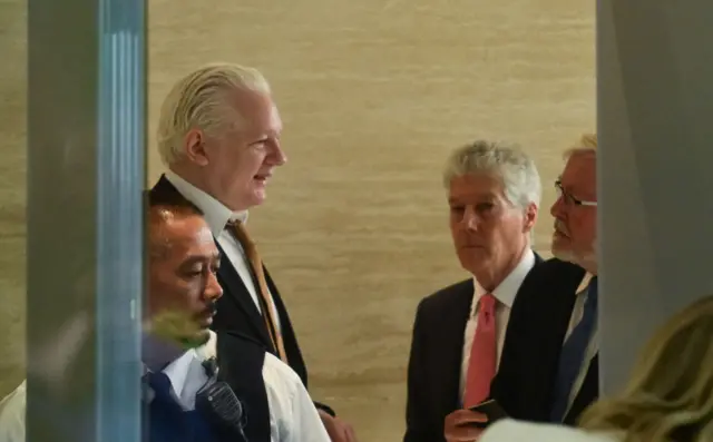 Assange at the court house with Stephen Smith (centre) and Kevin Rudd (right)