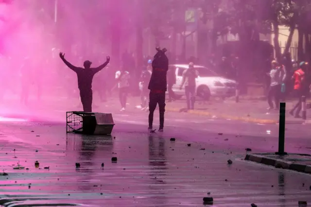 A pink haze of tear gas  descends on protesters