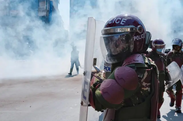 A member of the Kenyan security forces looks on from his helmet as he is deployed amid tear gas during a nationwide strike to protest against tax hikes and the Finance Bill 2024 in downtown Nairobi, on June 25, 2024