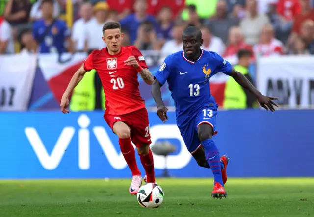 Sebastian Szymanski of Poland and N'Golo Kante of France compete for the ball