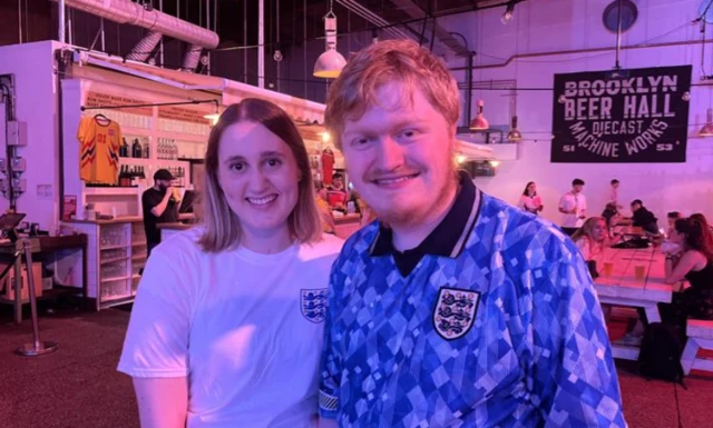 Ciara Aston and Adam Clark smile as they prepare to watch England at the Manchester fanzone