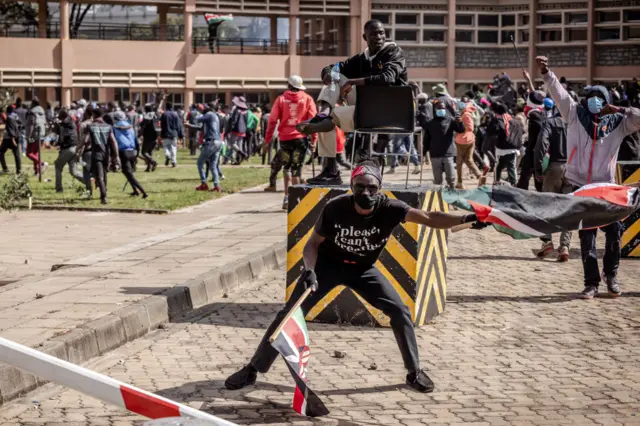 Protesters hold flags and chant anti-government slogans insider the Kenyan Parliament compound after storming the building during a nationwide strike to protest against tax hikes and the Finance Bill 2024 in downtown Nairobi, on June 25, 2024