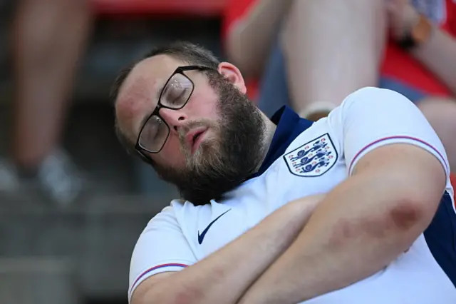 Fans of England and Slovenia wearing face paints support their team