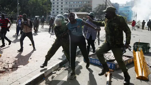 A protestor reacts next to the police during a demonstration against Kenya's proposed finance bill 2024/2025 in Nairobi, Kenya, June 25, 202