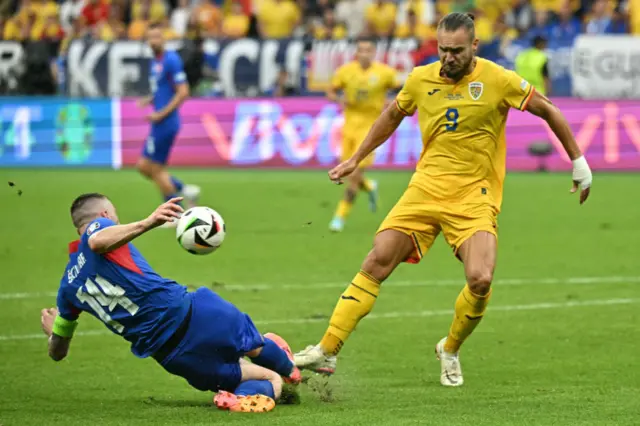 Milan Skriniar fights for the ball with Romania's forward George Puscas