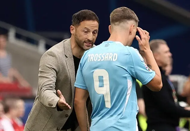 Domenico Tedesco and Belgium's Leandro Trossard react